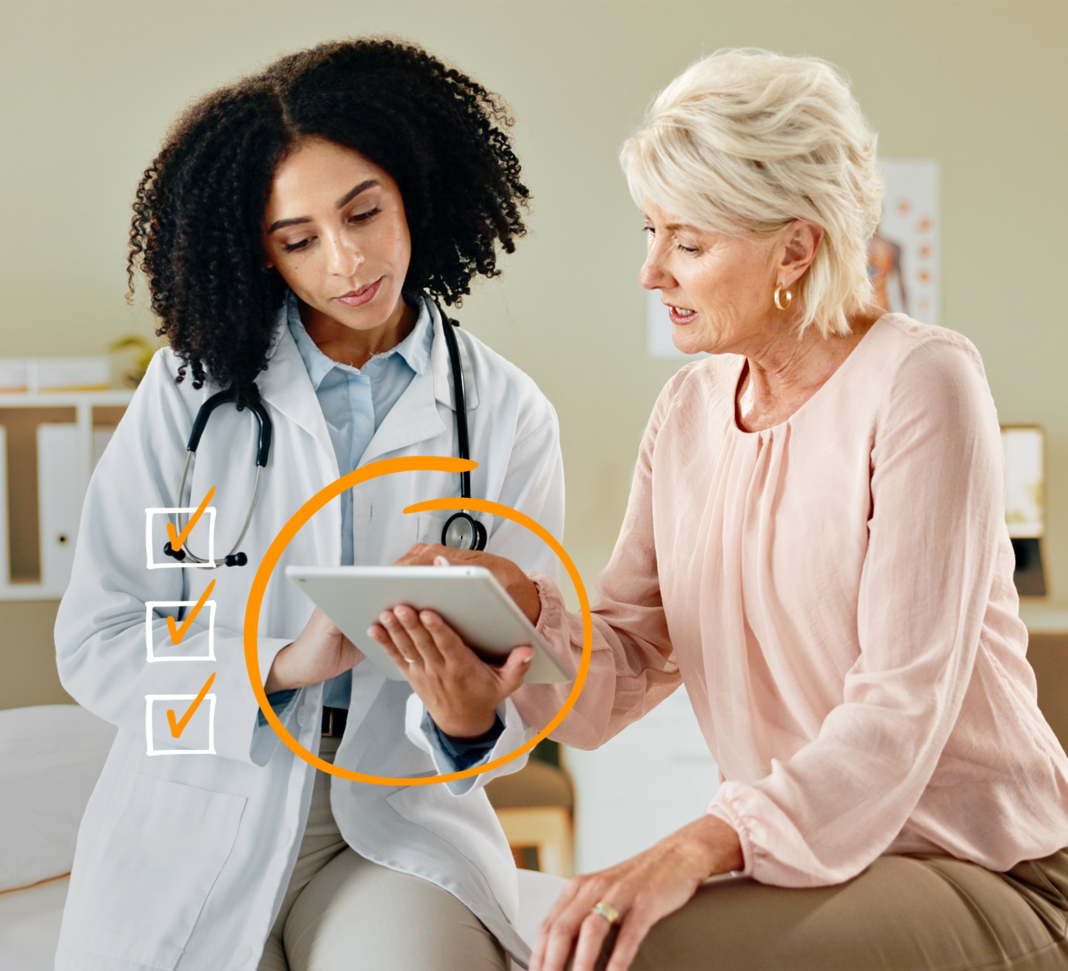 Doctor with a stethoscope sitting alongside an older female patient reviewing information on a tablet